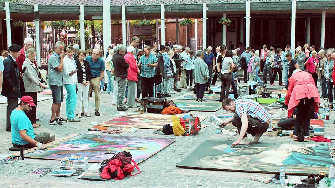 Madonnari-Künstler fertigen Bilder im Forum Pax Christi an.