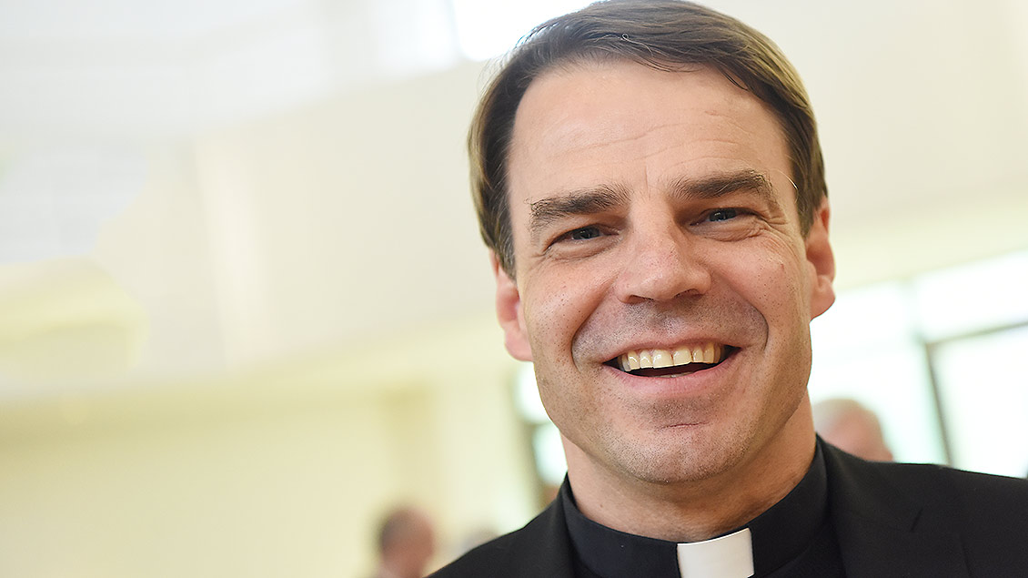 Bischof Stefan Oster lächelt in die Kamera.